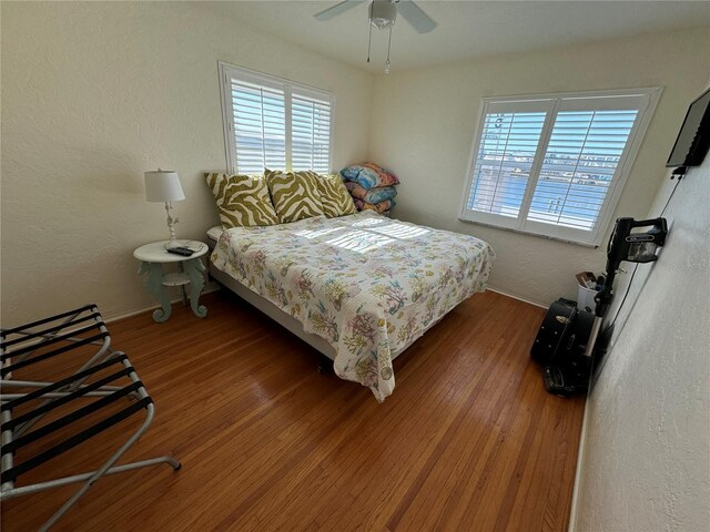 7886 9th Ave S, Saint Petersburg, FL 33707 - bedroom featuring multiple windows, wood finished floors, baseboards, ceiling fan, and a textured wall