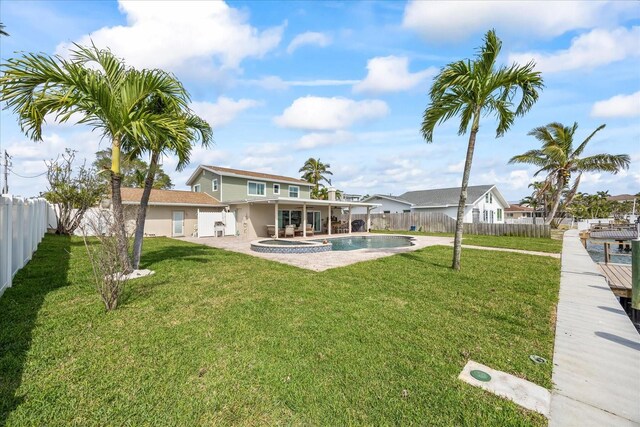 7886 9th Ave S, Saint Petersburg, FL 33707 - rear view of house featuring a pool with connected hot tub, stucco siding, and a patio