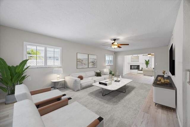 7886 9th Ave S, Saint Petersburg, FL 33707 - living area with ceiling fan, light wood-style flooring, baseboards, and a textured ceiling