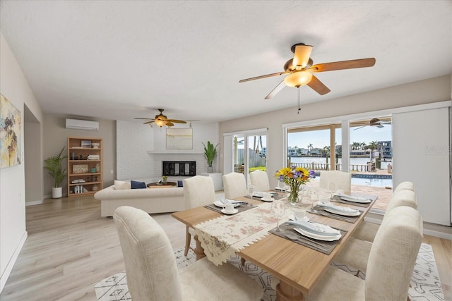 7886 9th Ave S, Saint Petersburg, FL 33707 - dining room featuring a wall mounted AC, ceiling fan, a water view, and a fireplace