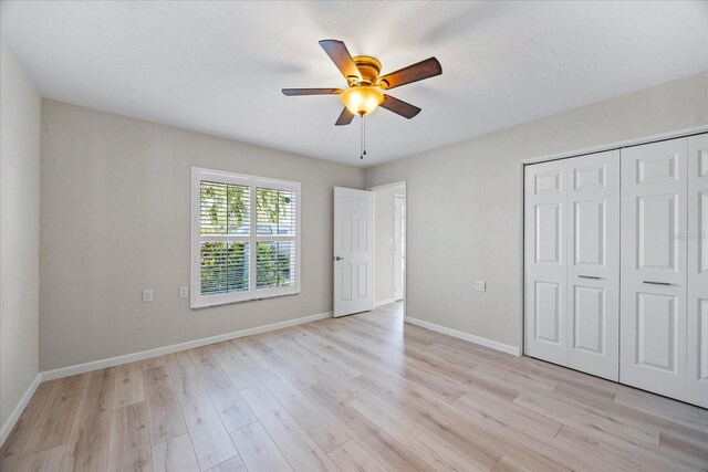 7886 9th Ave S, Saint Petersburg, FL 33707 - unfurnished bedroom featuring light wood-type flooring, a closet, baseboards, and a ceiling fan