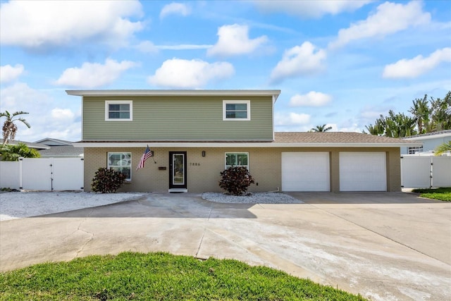 7886 9th Ave S, Saint Petersburg, FL 33707 - view of front of house featuring a gate, a garage, driveway, and brick siding