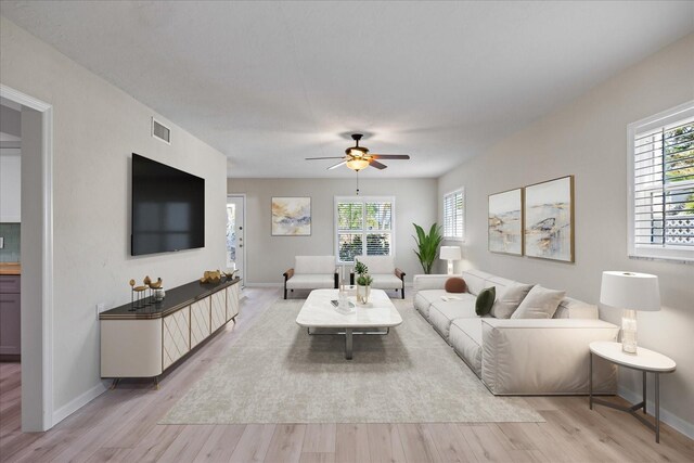 7886 9th Ave S, Saint Petersburg, FL 33707 - living room with a ceiling fan, light wood-style flooring, plenty of natural light, and baseboards