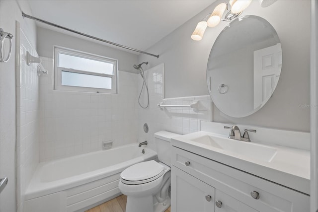 7886 9th Ave S, Saint Petersburg, FL 33707 - bathroom featuring vanity, toilet,  shower combination, wood finished floors, and tile walls