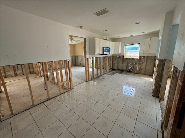 empty room with ceiling fan and light tile patterned floors