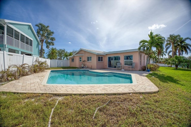 view of pool featuring a patio area, a yard, and a sunroom