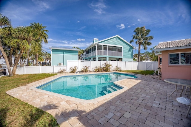 view of swimming pool with a patio and a sunroom