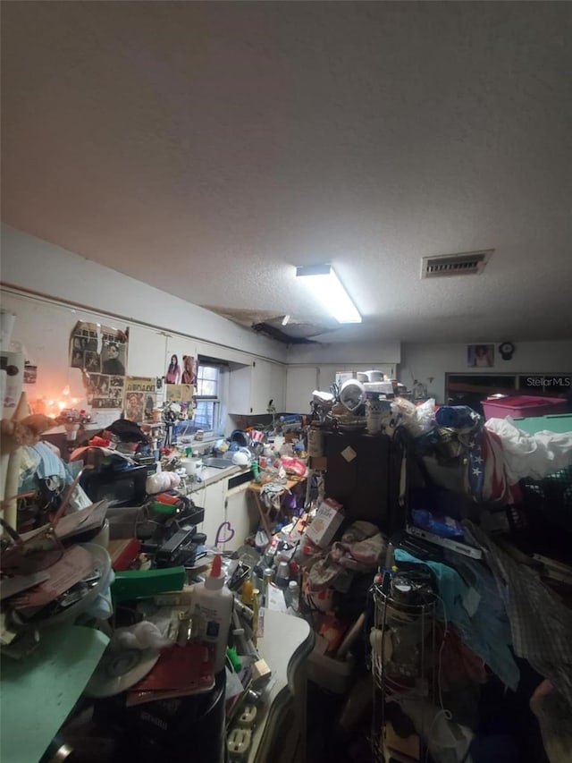 miscellaneous room with a textured ceiling