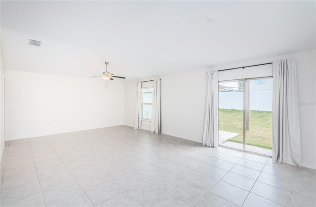 unfurnished room featuring visible vents, light tile patterned floors, a ceiling fan, and plenty of natural light