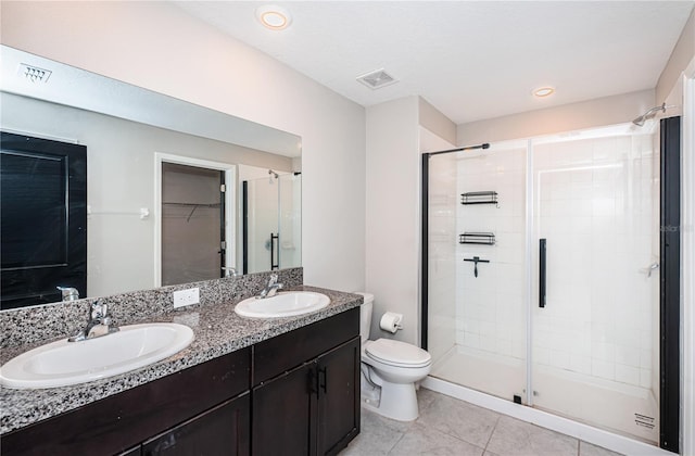 bathroom featuring toilet, walk in shower, vanity, and tile patterned floors