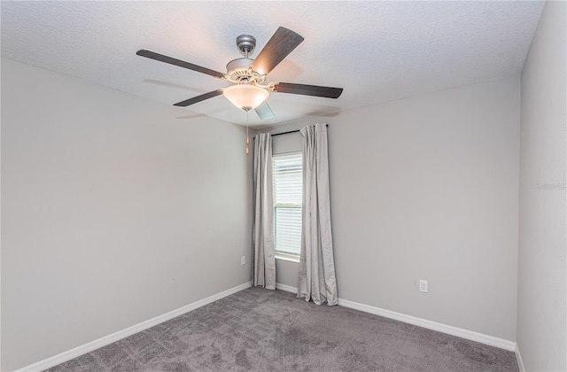 spare room featuring a textured ceiling, baseboards, a ceiling fan, and carpet floors