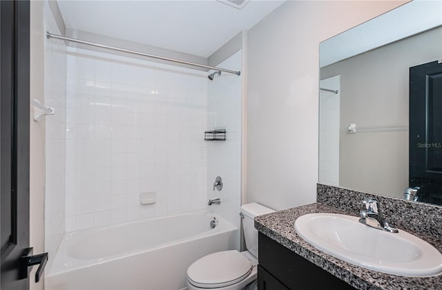 full bathroom featuring vanity, tiled shower / bath combo, and toilet