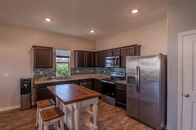 kitchen with sink, stainless steel appliances, light wood-type flooring, and tasteful backsplash