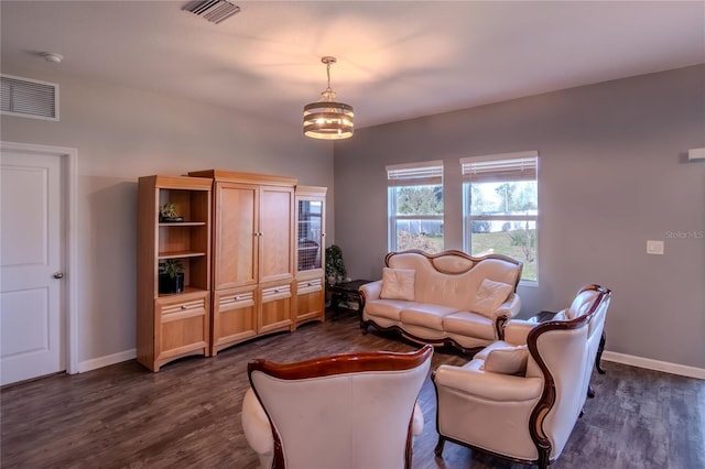 living room featuring a notable chandelier and dark wood-type flooring