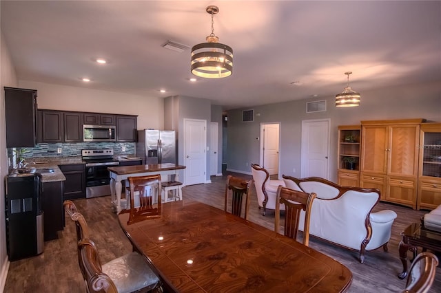 dining room featuring an inviting chandelier, sink, and dark wood-type flooring