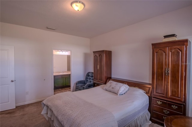 bedroom featuring connected bathroom and light colored carpet