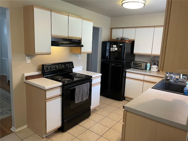 kitchen featuring black appliances, white cabinetry, sink, and light tile patterned floors