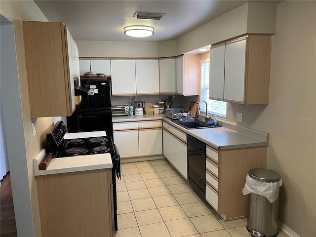 kitchen featuring black appliances, white cabinetry, sink, and light tile patterned floors