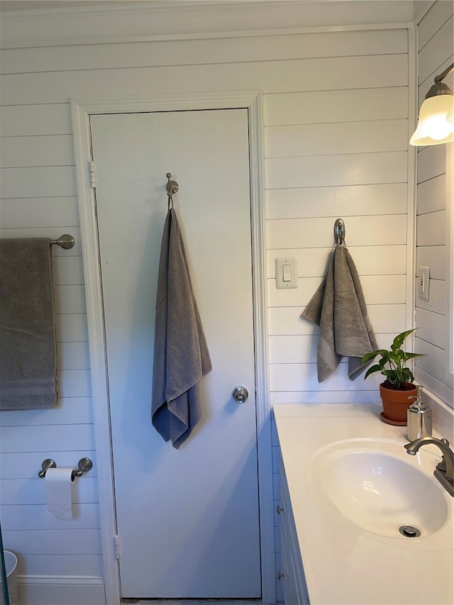 bathroom featuring wood walls and vanity