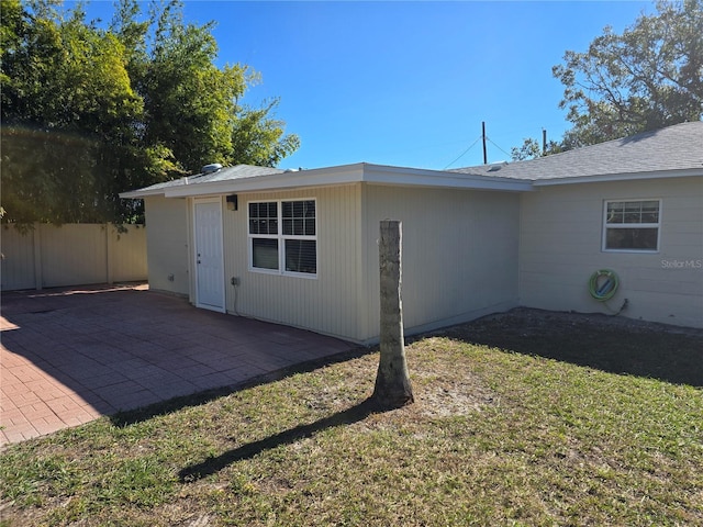 back of property featuring a patio area and a lawn