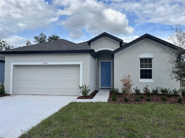 single story home with a garage and a front lawn