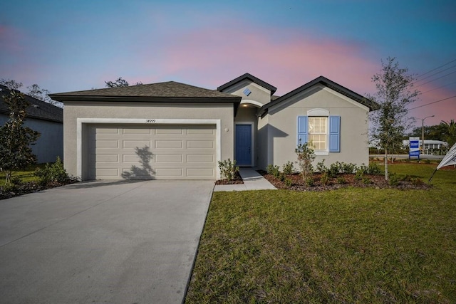 single story home featuring a garage and a lawn