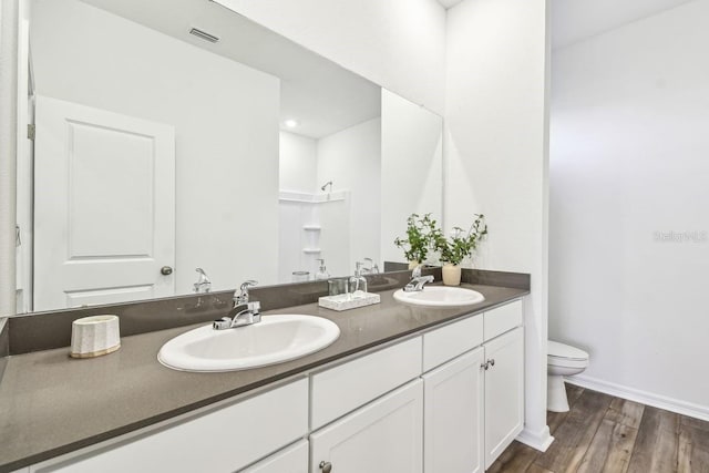 bathroom featuring vanity, hardwood / wood-style flooring, and toilet