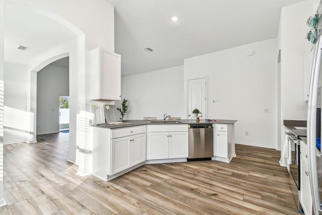 kitchen featuring stainless steel appliances, white cabinetry, sink, and light hardwood / wood-style floors