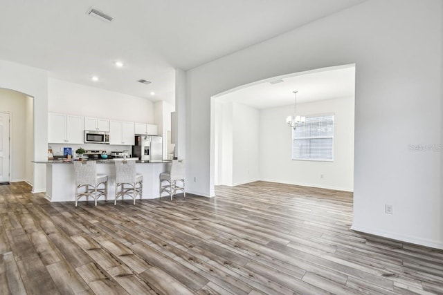 living room with an inviting chandelier and light hardwood / wood-style floors