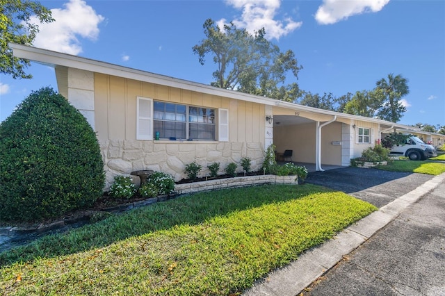 single story home featuring a front yard and a carport