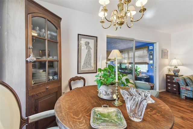 dining area with an inviting chandelier and dark wood-type flooring