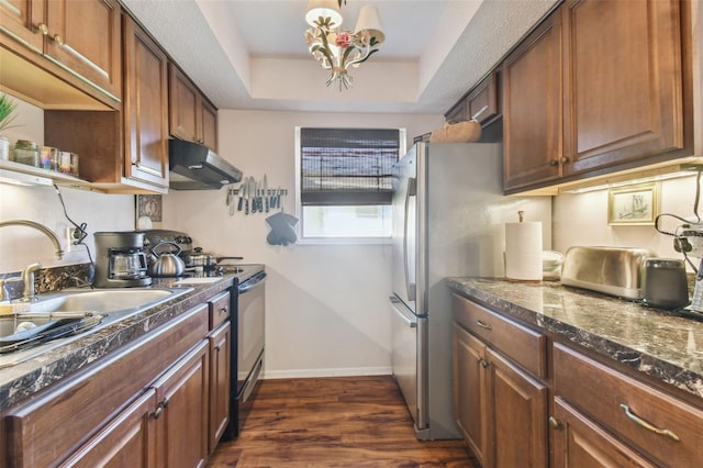 kitchen featuring a tray ceiling, electric range, stainless steel fridge, dark wood-type flooring, and an inviting chandelier