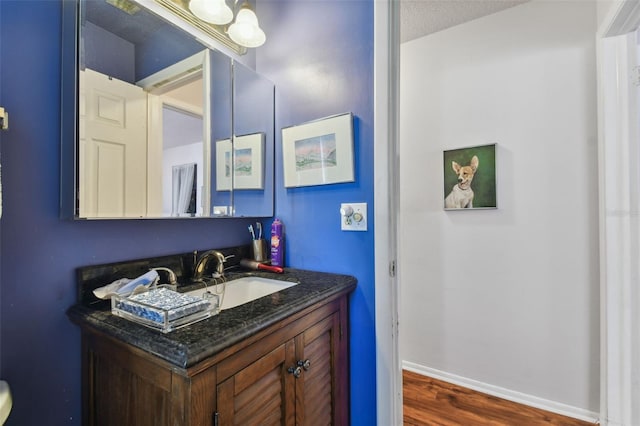 bathroom with vanity, hardwood / wood-style floors, and a textured ceiling