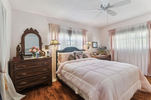 bedroom with ceiling fan, multiple windows, and dark hardwood / wood-style flooring