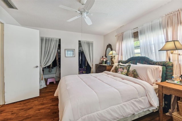 bedroom featuring dark wood-type flooring, ceiling fan, a closet, and a textured ceiling