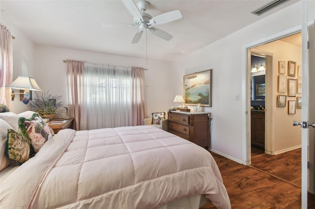 bedroom featuring a textured ceiling, dark wood-type flooring, and ceiling fan