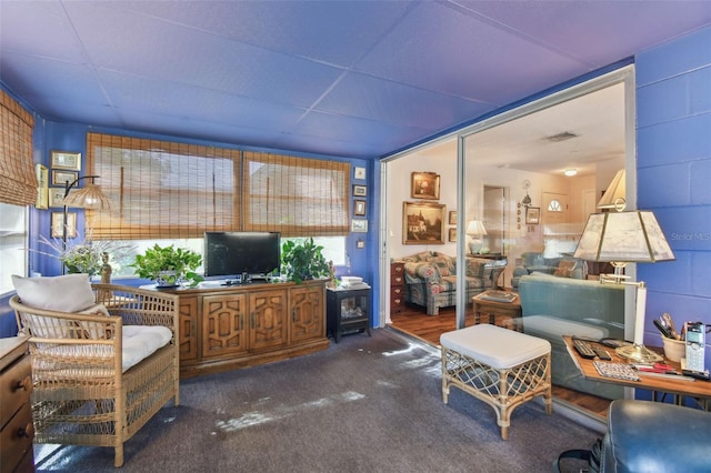 living room featuring plenty of natural light and dark colored carpet