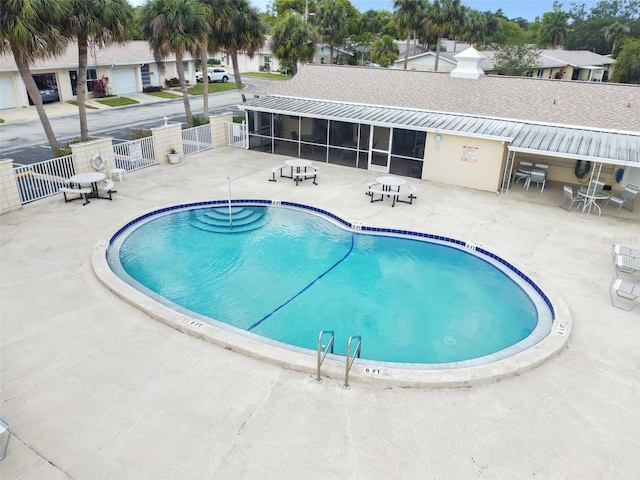 view of pool featuring a sunroom and a patio area