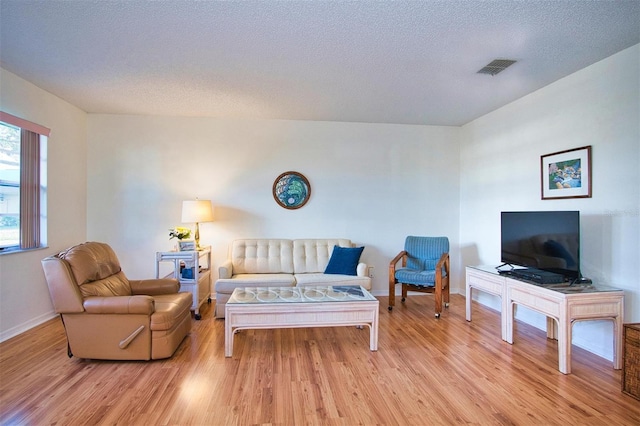 living room featuring light hardwood / wood-style floors and a textured ceiling