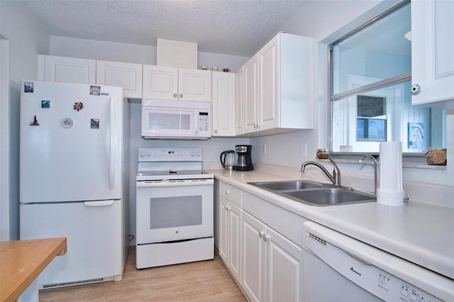 kitchen with sink, white cabinetry, light hardwood / wood-style flooring, and white appliances