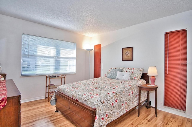 bedroom featuring light hardwood / wood-style floors and a textured ceiling