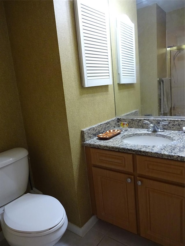 bathroom featuring vanity, toilet, tile patterned floors, and walk in shower