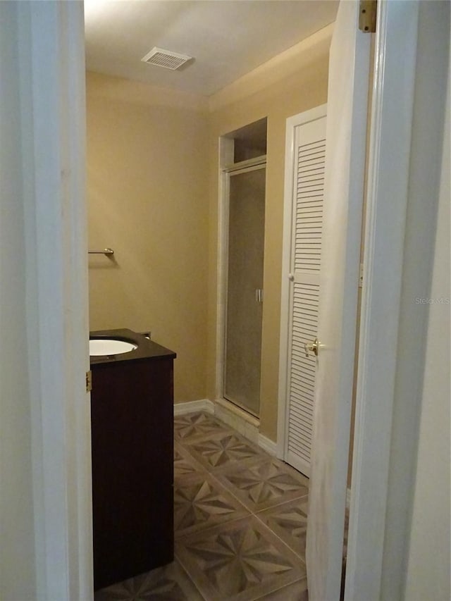 bathroom with vanity and a shower with door