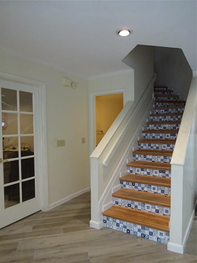 stairs featuring crown molding and hardwood / wood-style flooring