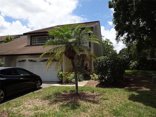 view of front of home with a front lawn and a garage