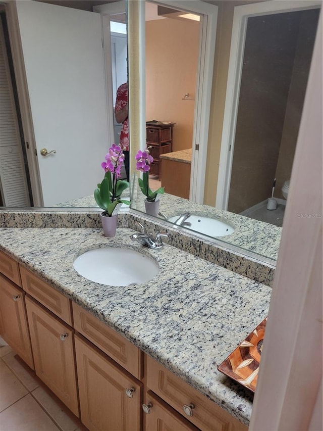 bathroom with vanity, toilet, and tile patterned flooring