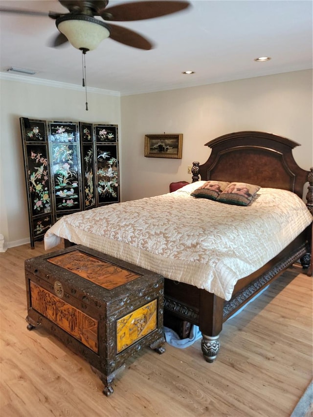 bedroom with ceiling fan, crown molding, and light wood-type flooring