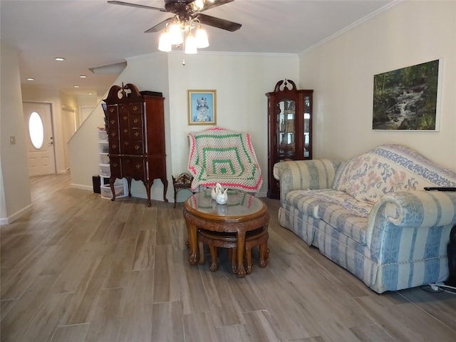 living room featuring ceiling fan, crown molding, and light hardwood / wood-style flooring