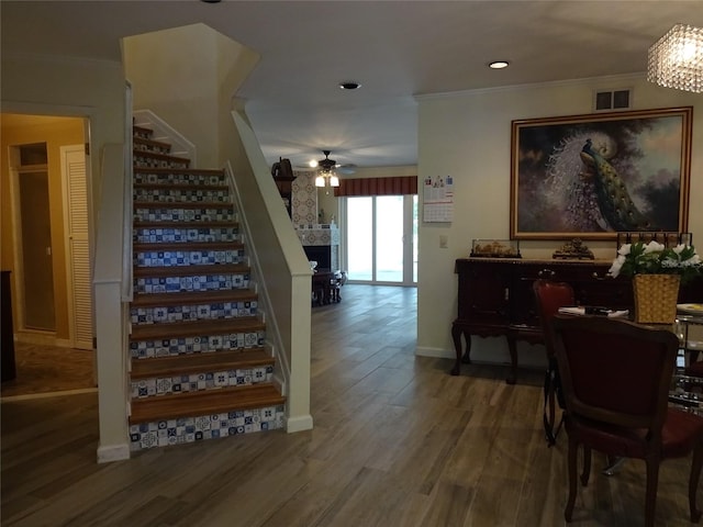 stairs featuring crown molding, hardwood / wood-style flooring, and ceiling fan