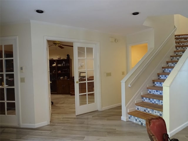 stairway with french doors, wood-type flooring, and ceiling fan